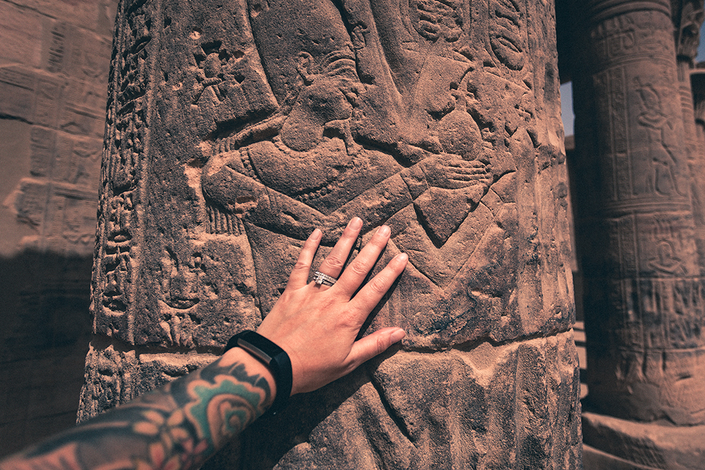 woman's hand on colonn in philae temple