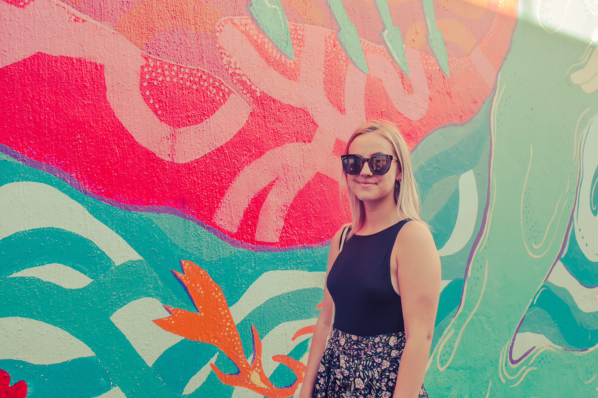 linn woman posing in front of a beautiful colourful wall